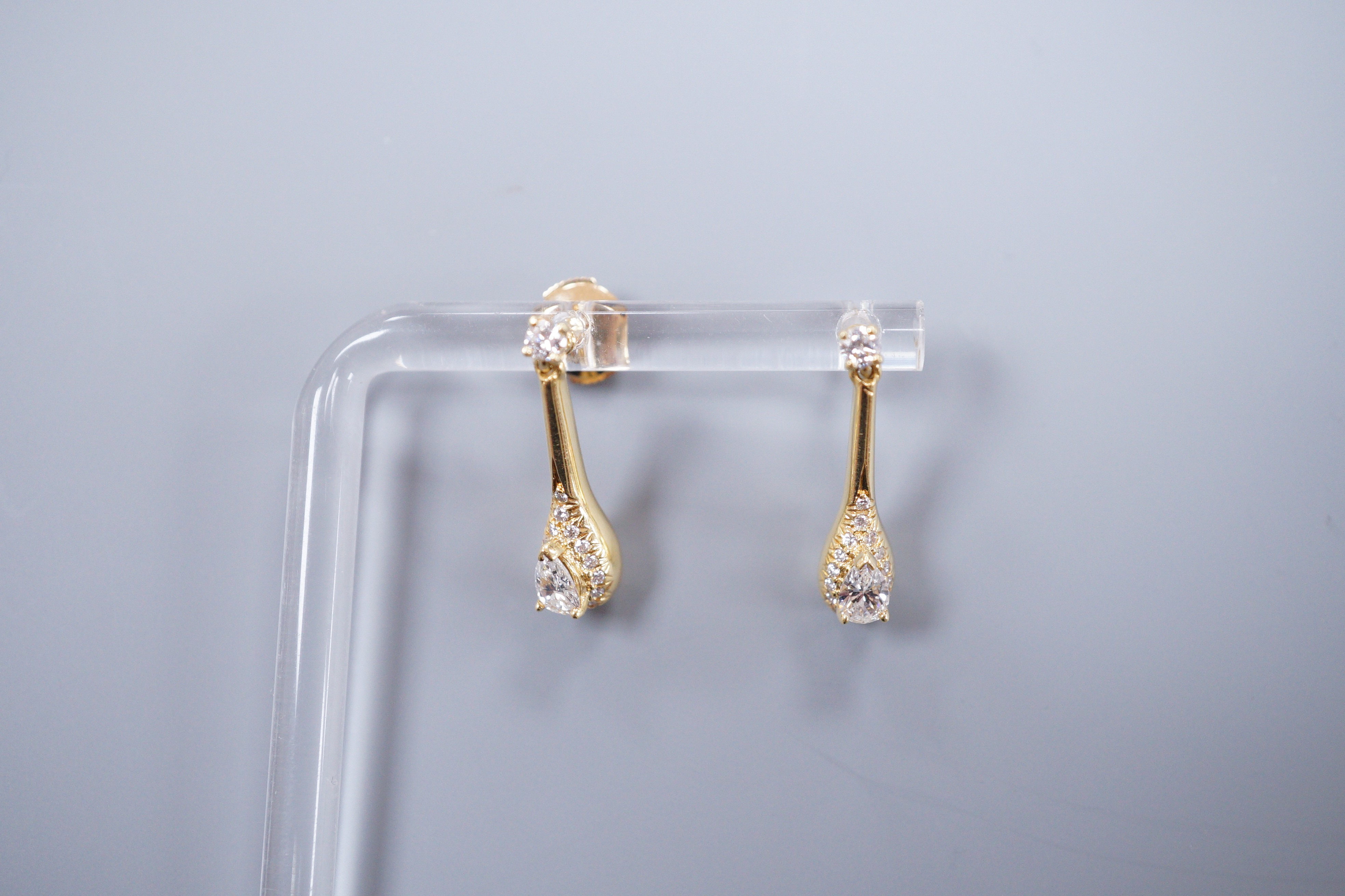 A pair of 18ct gold and diamond drop ear studs, each set with a tear shaped diamond within a border of brilliants, gross weight 5.3 grams